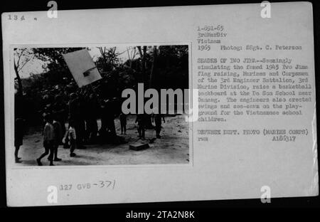 Marines und Korpsmänner des 3. Ingenieurbataillons der 3. Marine-Division heben ein Basketball-Backboard an der da Son Schule in der Nähe von Danang in Vietnam. Sie errichteten auch Schaukeln und Seesägen für die vietnamesischen Schulkinder in einem Akt des guten Willens. Das Foto wurde 1965 während des Vietnamkriegs aufgenommen. Stockfoto