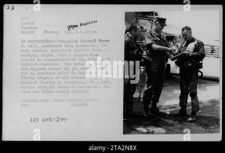 Brigadegeneral Homer S. Hill, stellvertretender Flügelkommandant, überreicht Captain Peter A. Krueger eine Gedenktafel für seine 500. A-4B-Mission Skyhawk. Krueger kann den Rekord für die höchste Anzahl von Jet Combat Missionen eines amerikanischen Piloten in Südostasien halten. Colonel Charles B. Armstrong Jr., Flügelmann auf dem Flug, flog seine 100. Kampfmission. Stockfoto