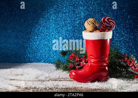 St. Nicholas-Tag. Roter Stiefel mit Süßigkeiten, scharfen Ingwerkeksen und Geschenken für den 6. Dezember Stockfoto