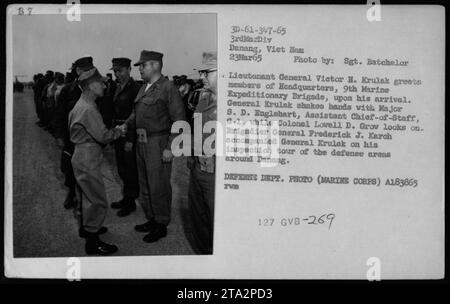 Generalleutnant Victor H. Krulak begrüßt die Mitglieder des Hauptquartiers der 9. Marine Expeditionary Brigade bei seiner Ankunft in Danang, Vietnam, am 23. März 1965. Er schüttelt die Hand mit Major S. D. Englehart, stellvertretender Stabschef G-1, während Colonel Lowell D. Grow beobachtet. Brigadegeneral Frederick J. Karch begleitet Krulak während seiner Inspektionsreise durch die Verteidigungsgebiete. Stockfoto