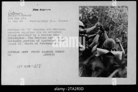 Marines von 'B' Company, 4th Marines, werden gezeigt, wie sie Vorräte von einem Marine CH-46 Hubschrauber mit einem externen Schleuder erhalten. Dieses Foto wurde am 31. Dezember 1968 während des Vietnamkriegs im Rahmen der Operation Scotland II aufgenommen Das Hotel liegt nördlich von Vandergrift. Stockfoto