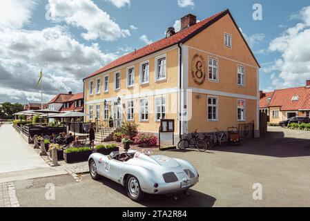 Eine silberfarbene Porsche 718 Spyder Nachbildung parkt vor der Terrasse vor einem Restaurant in aHUS im Sommer, Skåne, Schweden Stockfoto