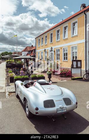 Eine silberfarbene Porsche 718 Spyder Nachbildung parkt vor der Terrasse vor einem Restaurant in aHUS im Sommer, Skåne, Schweden Stockfoto