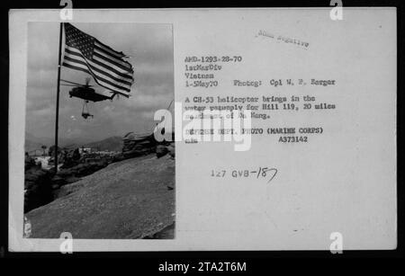 Eine Flaggenzeremonie des U.S. Marine Corps findet am 1. Mai 1970 während des Vietnamkriegs statt. Auf dem Bild ist ein CH-53 Hubschrauber zu sehen, der Wasservorräte nach Hill 119 bringt, der 20 Meilen südwestlich von da Nang liegt. Das Foto wurde von CPL W.P. Berger aufgenommen und ist Teil des Archivs des Verteidigungsministeriums. Stockfoto