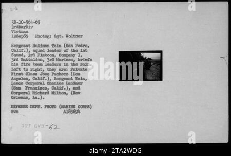 Sergeant Muliman Tela von Kompanie I, 3. Bataillon, 3. Marines beschriftet seine Anführer der Feuerwehrmannschaft im Regen während des Vietnamkriegs. Die Personen auf dem Foto sind der private First Class Jose Pacheco, Sergeant Tela, Lance Corporal Charles Landaur und Corporal Richard Milton. Das Foto wurde am 19. September 1965 in der vietnamesischen Provinz Quảng Nam aufgenommen. Stockfoto