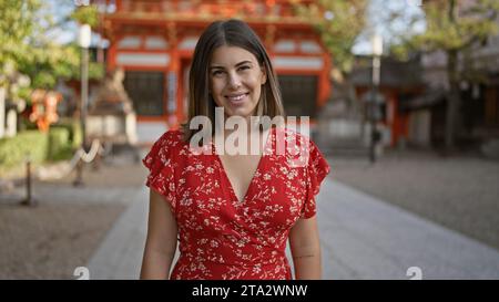 Die wunderschöne hispanische Frau posiert strahlend, lacht und lächelt und strahlt Selbstvertrauen aus im yasaka-Tempel in kyoto, japan. Stockfoto