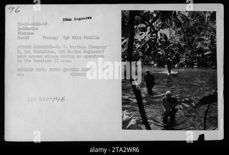 US-Marines der Kompanie B, 1. Bataillon, 4. Marine-Regiment, überqueren einen Fluss während der Operation Scotland II im Dezember 1968. Dieses Foto, aufgenommen von Sgt Miko Padilla, fängt einen Moment während des Kampfes in Vietnam ein. Das Bild ist ein 35-mm-negativ und ist Teil der Fotosammlung des Verteidigungsministeriums. Stockfoto