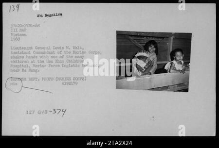 Generalleutnant Lewis W. Walt, Assistenzkommandant des Marine Corps, schüttelt während des Vietnamkriegs 1968 im Hoa Khan Children's Hospital in der Nähe von da Nang die Hand mit einem Kind. Das Bild zeigt die amerikanischen Militäraktivitäten und ihre Interaktionen mit dem vietnamesischen zivilen Leben. Stockfoto