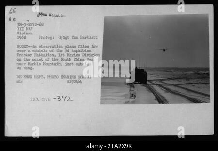 Ein Beobachtungs-Flugzeug fliegt tief über einem Fahrzeug des 3. Amphibien-Traktorbataillons, 1. Marine-Division an der Küste des Südchinesischen Meeres nahe dem Marmor-Berg, außerhalb von da Nang. Fotografiert vom Marine Corps GySgt Tom Bartlett 1968 während des Vietnamkriegs. Stockfoto