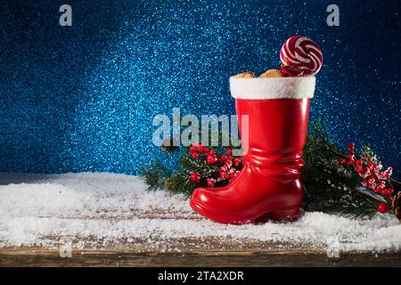 St. Nicholas-Tag. Roter Stiefel mit Süßigkeiten, scharfen Ingwerkeksen und Geschenken für den 6. Dezember Stockfoto