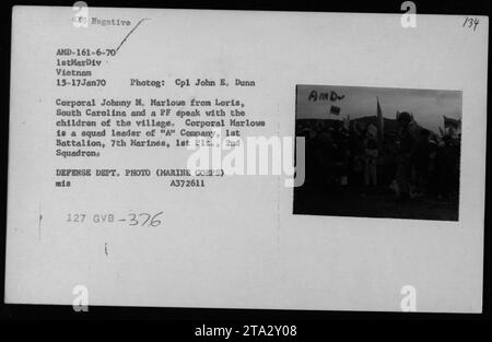 CPL Johnny M. Marlowe aus Loris, South Carolina und eine PF interagieren mit Kindern in einem vietnamesischen Dorf. CPL Marlowe, ein Truppenführer der A-Kompanie, 1. Bataillon, 7. Marines, wird vom 15. Bis 17. Januar 1970 in Vietnam in einem freundschaftlichen Gespräch beobachtet. Dieses Foto fängt Momente ziviler Interaktionen während des Vietnamkriegs ein.“ Stockfoto