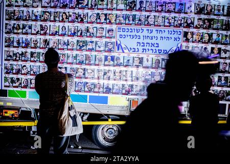 Tel Aviv, Israel. November 2023. Eine Person schaut sich Fotos von entführten Israelis an, die von der Hamas in Gaza als Geisel gehalten wurden. Die Hamas ließ am Sonntag 17 weitere Geiseln frei, darunter ein amerikanischer Avigail Idan, der am Freitag 4 Jahre alt wurde und sagte, dass er versuchen werde, einen vorübergehenden Waffenstillstand mit Israel zu verlängern, nachdem die derzeitige viertägige Pause beendet ist. Nach dem Abkommen, das letzte Woche erzielt wurde, begann der Waffenstillstand am Freitag und soll bis Montag fortgesetzt werden. Es ist der längste Bruch-Kampf in Gaza seit dem 7. Oktober, als bewaffnete der Hamas und anderer militanter Gruppen einen tödlichen Angriff auf Süd-Israel starteten, bei dem etwa 1, 2 Menschen ums Leben kamen Stockfoto