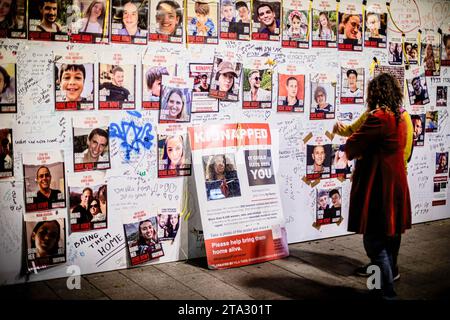 Tel Aviv, Israel. November 2023. Die Menschen sehen sich Fotos von entführten Israelis an, die von der Hamas in Gaza als Geisel gehalten wurden. Die Hamas ließ am Sonntag 17 weitere Geiseln frei, darunter ein amerikanischer Avigail Idan, der am Freitag 4 Jahre alt wurde und sagte, dass er versuchen werde, einen vorübergehenden Waffenstillstand mit Israel zu verlängern, nachdem die derzeitige viertägige Pause beendet ist. Nach dem Abkommen, das letzte Woche erzielt wurde, begann der Waffenstillstand am Freitag und soll bis Montag fortgesetzt werden. Es ist der längste Bruchkampf in Gaza seit dem 7. Oktober, als bewaffnete Männer der Hamas und anderer militanter Gruppen einen tödlichen Angriff auf Südisrael starteten, bei dem etwa 1.200 Menschen ums Leben kamen Stockfoto