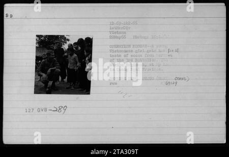 Ein junges vietnamesisches Mädchen, das zum ersten Mal Kakao von Marines des 3. Bataillons, 7. Marineregiment, während der Operation Morgan in Ly La, Provinz Quang Ngai, verkostet. Foto am 22. Mai 1966 von ICpl. Verteidigungsabteilung Foto (Mar Corps). Referenznummer: GVB-289 1D-69-142-66 1stMarDiv Vietnam. Stockfoto