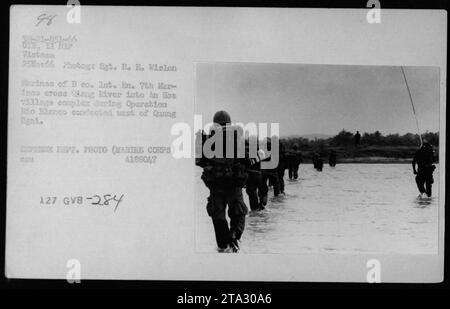 Marinesoldaten der Kompanie B, des Battalion Landing Team 7th Marines, werden während der Operation Mo Blanco in der westlichen Provinz Quang Ngai am 25. November 1966 gesehen, wie sie den Fluss eng in den an Hos-Dorfkomplex überquerten. Sie führten Patrouillen als Teil ihrer Mission während des Vietnamkriegs durch. Stockfoto