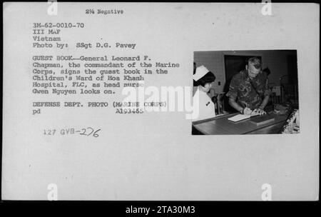 General Leonard F. Chapman unterschreibt das Gastbuch in der Kinderabteilung des Hoa Khanh Krankenhauses in Vietnam, während Schulkrankenschwester Gwen Nguyen am 10. Januar 1970 beobachtet. Stockfoto