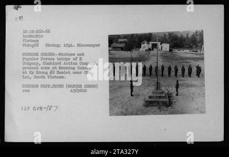 Marines und Popular Forces Truppen der K Company, Combined Action Company, führen eine Flaggenzeremonie namens Morning Colors in Ky Houng #2 Hamlet in der Nähe von Chu Lai, Südvietnam, durch. Das Foto wurde am 24. August 1966 von ICpl aufgenommen. Mincemoyer. Dieses Bild zeigt die Zusammenarbeit zwischen amerikanischen und südvietnamesischen Truppen während des Vietnamkriegs. Stockfoto