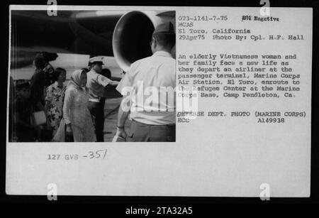 Eine vietnamesische Flüchtlingsfamilie geht von einem Flugzeug an der Marine Corps Air Station El Toro aus. Die ältere Frau und ihre Familie sind am 29. April 1975 auf dem Weg zum Refugee Center auf der Marine Corps Base in Camp Pendleton, Kalifornien. Foto von CPL. H.F. Hall. Foto des Verteidigungsministeriums (Marine Corps) Bildunterschrift: Vietnamesische Flüchtlinge kommen an der Marine Corps Air Station in El Toro, Kalifornien an und suchen ein neues Leben im Refugee Center in der Marine Corps Base in Camp Pendleton. Stockfoto