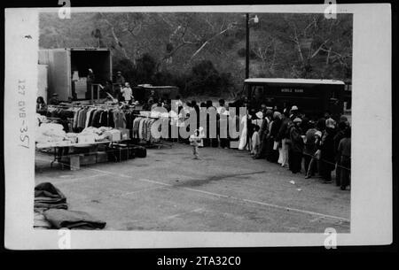 Gruppenfoto vietnamesischer Flüchtlinge in den Vereinigten Staaten, aufgenommen am 14. Mai 1975. Abgebildet sind Claudia Cardinale, Nguyen Cao Ky, Rosemary Clooney und Betty Ford. Das Bild zeigt, wie sie die Flüchtlinge in einer scheinbar mobilen Bank besuchen, die als GVB-351 bezeichnet wird. Weitere Details sind nicht verfügbar. Stockfoto