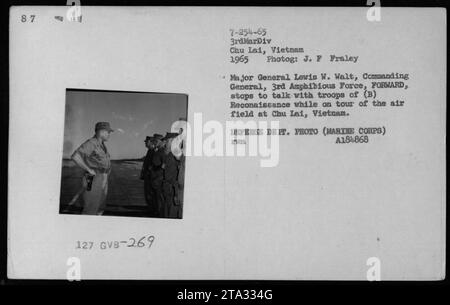 Generalmajor Lewis W. Walt, Kommandierender General der 3. Amphibien-Streitmacht, spricht mit Truppen der Aufklärung während seines Besuchs auf dem Chu Lai Flugplatz in Vietnam. Das Foto wurde 1965 von J. F. Fraley aufgenommen und ist Teil der Fotografien amerikanischer Militäraktivitäten während der Sammlung des Vietnamkriegs. Stockfoto