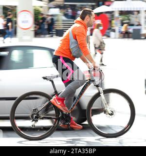 Belgrad, Serbien - 2. Oktober 2020: Ein Mann in leuchtenden Farben, der auf der belebten Straße der Stadt Fahrrad fährt Stockfoto