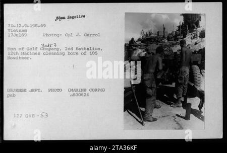 Soldaten der Golf Company, 2. Bataillon, 12. Marines, in Vietnam, werden am 17. Juli 1969 gesehen, wie sie die Bohrung einer 105-mm-Haubitze reinigen. Das Foto von CPL. Carrol Batt zeigt die Wartungsarbeiten, die die Männer der Golf Company während des Krieges durchgeführt haben." Stockfoto