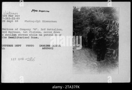 Am 20. September 1969 navigierten Marines der Kompanie M, 3rd Battalion, 3rd Marines, 1st Platoon, während Patrouillenoperationen einen Wasserlauf in der Nähe der entmilitarisierten Zone in Vietnam und demonstrierten die Herausforderungen der Feldoperationen. Stockfoto