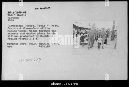 Generalleutnant Lewis W Walt, stellvertretender Kommandant des Marine Corps, wird durch die Straßen und den Marktplatz eines von der Combined Action Patrol 1-3-5 geschützten Dorfes in Vietnam gesehen. Dieses Foto wurde 1968 während des Vietnamkriegs aufgenommen. Stockfoto