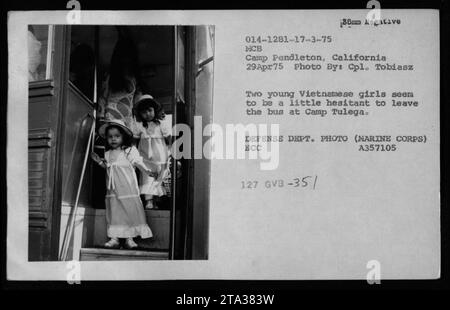 Marine Corps Base (MCB) Camp Pendleton, Kalifornien, 29. April 1975: Auf diesem Foto des Verteidigungsministeriums (Marine Corps) erscheinen zwei junge vietnamesische Mädchen besorgt über den Ausstieg aus dem Bus bei der Ankunft in Camp Tulega. Sie werden zusammen mit anderen vietnamesischen Flüchtlingen von Claudia Cardinale, Nguyen Cao Ky, Rosemary Clooney und Betty Ford besucht. Stockfoto