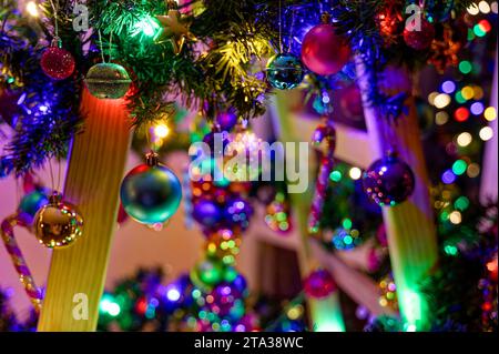 Farbenfrohe Weihnachtsdekoration auf einer Holzleiter als Alternative zu einem Weihnachtsbaum. Stockfoto