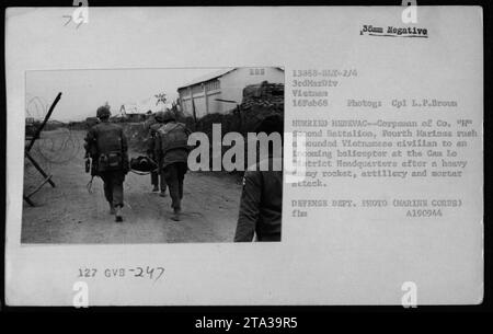 Als Korpist des Zweiten Bataillons tragen die Vierten Marines schnell einen verwundeten vietnamesischen Zivilisten zu einem wartenden Helikopter im Hauptquartier des Bezirks Cam Lo, nachdem ein feindlicher Angriff mit Raketen, Artillerie und Mörsern stattgefunden hat. Dieses Foto wurde am 16. Februar 1968 während eines Medical Civil Action Program (MEDCAP) in Vietnam aufgenommen. Stockfoto