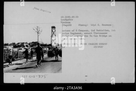 US-Marines der G-Kompanie, 2. Bataillon, 1. Marine-Regiment, begleiten vietnamesische Zivilisten auf der Überquerung der Tu-Cau-Brücke, um am 7. September 1969 während des Vietnamkriegs nach Hause zurückzukehren. Stockfoto