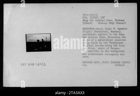 Der Marine-Berater Major Roger W. Badeker (Manhattan, Kansas), der an Operationen in der Sang Sat Special Zone in Vietnam beteiligt ist, wird im Bild über eine Position am Wasser diskutiert, die von den vietnamesischen Regionalstreitkräften entlang des Long Tao River südlich von Saigon gebaut wird. Auf dem Foto wird der überwiegend mittelflache Hintergrund des Bereichs hervorgehoben. Foto des Verteidigungsministeriums von Master Sergeant Stewart, aufgenommen am 31. Dezember 1965. Stockfoto