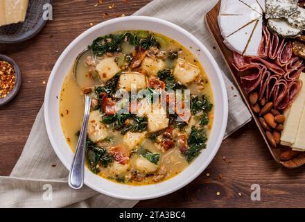 Zuppa toscana Suppe mit Blumenkohlgnocchi, serviert mit Wurst- und Käsesorten. Stockfoto