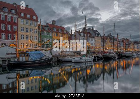 Fischerboote zwischen glitzernden Weihnachtsdekorationen im Kopenhagener Nyhavn-Kanal, 25. November 2023 Stockfoto