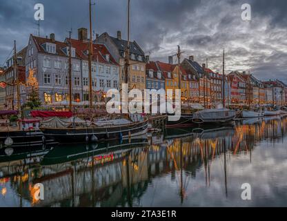 Weihnachtsdeokorationen spiegeln sich am 25. November 2023 im Kopenhagener Nyhavn-Kanal in der Abenddämmerung wider Stockfoto