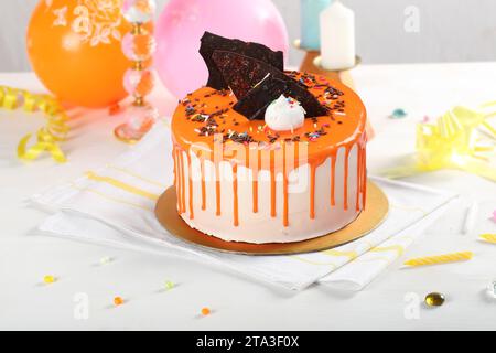 Orangefarbenes tropfenförmiges Hintergrundbanner mit Partydekor. Kopierbereich. Feier-Konzept. Trendiger Tropfkuchen. Selektiver Fokus. Stockfoto