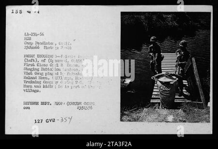 Bildunterschrift: Vietnamesische Viet Cong Verdächtige und Gefangene wurden während des Vietnamkrieges 1966 in Camp Pendleton, Kalifornien, von amerikanischen Militärs festgenommen. Das Foto zeigt einen vietnamesischen Mann, der inhaftiert wird, während ein weiterer amerikanischer Marine in der Nähe steht. Stockfoto