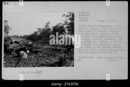 Der Marine-Kampffotograf, CPL. Scott M. Leighty, macht ein Foto von Korpsleuten, die verwundete Marines nach einer Explosion behandelt haben, bei der Dr. B. Fall und GySgt getötet wurden. Byron G. Highland. Im Hintergrund führen Marines von A 1/9 während der Operation Chinook II einen schweren Feuergefecht im Dorf AP Trung Kiau, R.V.N. Foto am 21. Februar 1967 von H.L. Shaw für Time/Life. Stockfoto