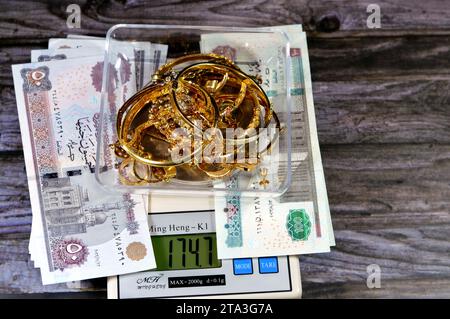 Kairo, Ägypten, 9. November 2023: Stapel Gold auf einer digitalen Ming Heng K1 Skala in Gramm mit EGP ägyptischen Geldpounds Bargeld-Banknoten, Armband Stockfoto