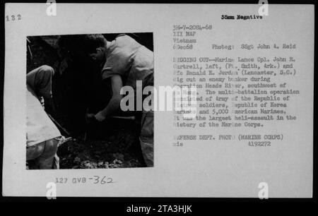 John R. Cartrell und Pre Ronald E. Jordan graben am 6. Dezember 1968 während der Operation Head River südwestlich von da Nang einen Viet Cong Bunker aus. Die Operation war der größte Heli-Angriff in der Geschichte des Marine Corps. Stockfoto