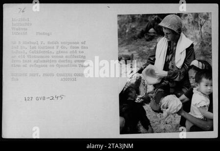 Leichenmann HN 3 Michael F. Smith aus der 2. BN. 1st Marines F Co. Aus San Rafael, Kalifornien, leistet Hilfe für eine ältere vietnamesische Frau, die während der Evakuierung von Flüchtlingen im Rahmen der Operation Teton unter Hitzeerschöpfung leidet. Dieses Foto wurde am 14. Oktober 1966 im Rahmen eines Medical Civilian Action Program (MEDCAP) aufgenommen, das von der 1st Marine Division in Vietnam durchgeführt wurde.“ Stockfoto