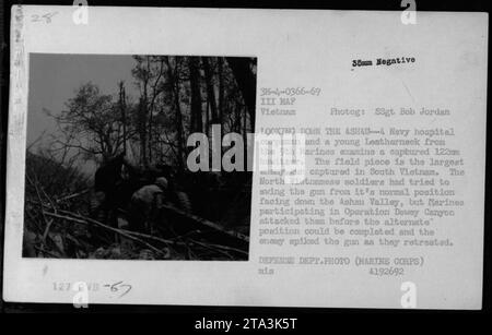 Auf diesem Foto, das 1966 während des Vietnamkriegs aufgenommen wurde, sehen Sie einen Navy-Krankenhaus-Korpsman und einen jungen Marine der 9. Marines, die eine gefangengenommene 122-mm-Haubitze untersuchen. Dies war die größte feindliche Waffe, die in Südvietnam gefangen genommen wurde, wobei nordvietnamesische Soldaten versuchten, sie in das Ashau-Tal zu versetzen. Während der Operation Dewey Canyon intervenierten die US-Marines jedoch, was die Vollendung der Neupositionierung verhinderte und den Feind zwang, die Waffe vor dem Rückzug zu picken. Dieses Bild ist vom Verteidigungsministerium (Marine Corps). Stockfoto