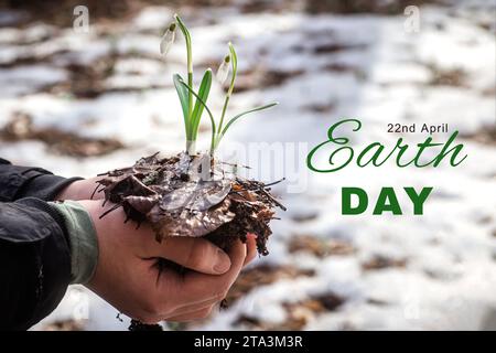 Tag Der Erde. Frische Schneeglöckchen mit Boden in den Händen eines Kindes. Pflege des Umweltkonzepts Umwelt sparen, sauberen Planeten retten, Ökologie heimlich Stockfoto