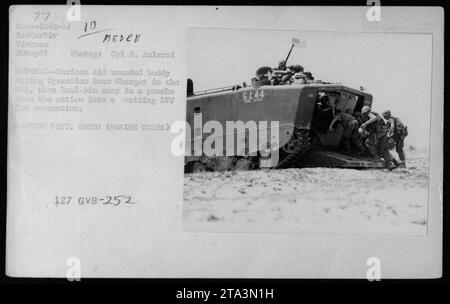 Während der Operation Beau Charger in Vietnam helfen US-Marines einem verwundeten Kameraden. Sie tragen ihn in einem Poncho zu einem wartenden LVT (Landing Vehicle Tracked) zur Evakuierung. Dieses Foto wurde am 20. Mai 1967 aufgenommen und ist Teil einer Serie, die die militärischen Aktivitäten der USA während des Vietnamkriegs dokumentiert. Stockfoto