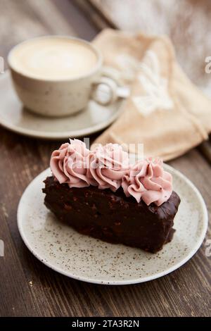 Traditioneller Brownie-Kuchen mit einer Tasse Cappuccino im Freien. Winter-Ästhetik. Stockfoto