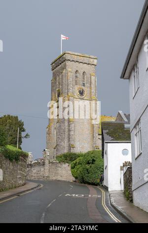 Kirche der Heiligen Dreifaltigkeit, Salcombe, in der Wintersonne, unterging vor einem grauen Himmel und flog mit dem Kreuz des Heiligen Georg, vom Stadtzentrum entfernt am Ende der Kirche Str Stockfoto