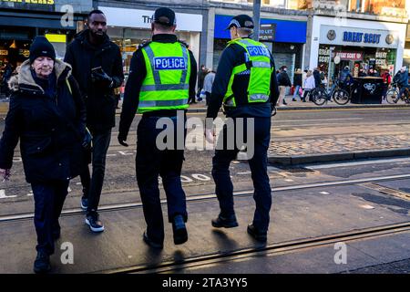 Polizei von Schottland Polizeibeamte benutzen Eine Fußgängerüberfahrt, während sie Princes Street, Edinburgh, Großbritannien, patrouillieren Stockfoto