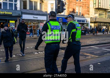 Polizei von Schottland Polizeibeamte benutzen Eine Fußgängerüberfahrt, während sie Princes Street, Edinburgh, Großbritannien, patrouillieren Stockfoto