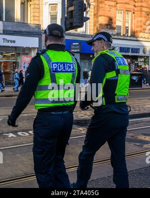 Polizei von Schottland Polizeibeamte benutzen Eine Fußgängerüberfahrt, während sie Princes Street, Edinburgh, Großbritannien, patrouillieren Stockfoto